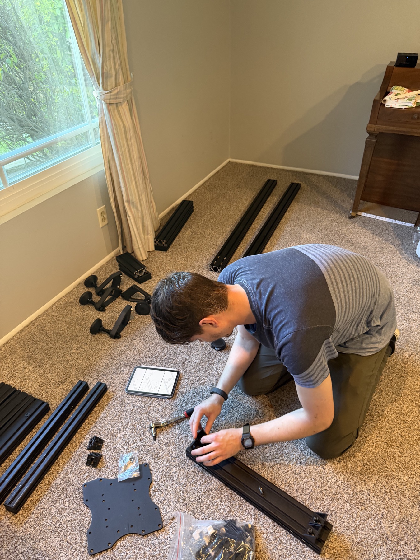 James assembling the aluminum frame of a sim racing cockpit by hand.
