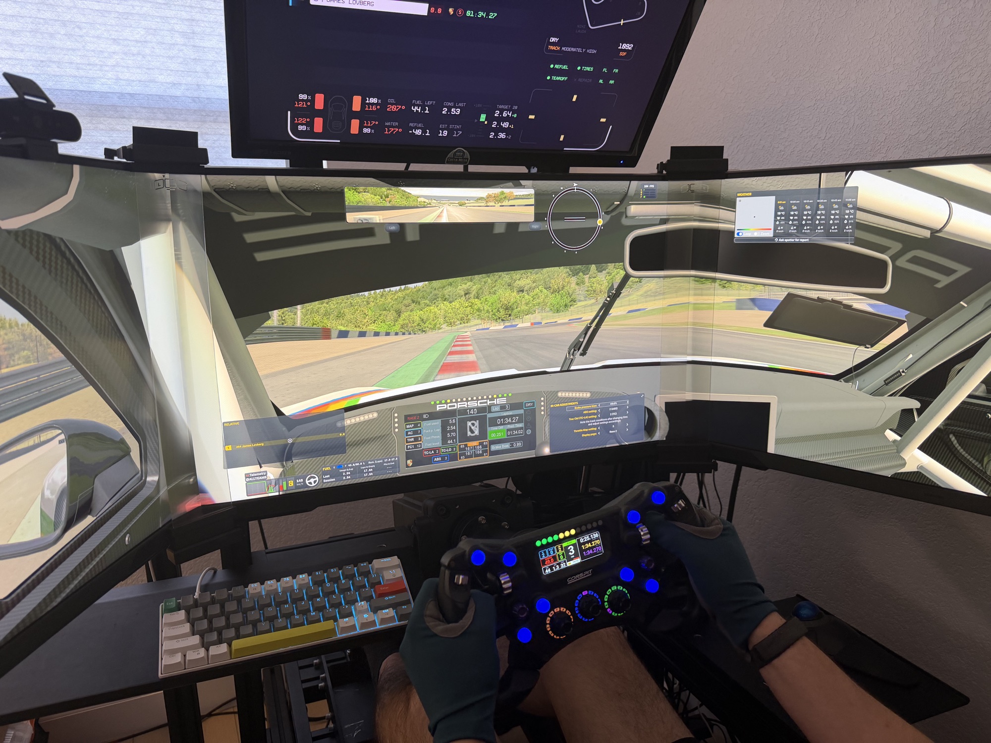 Triple-screen sim racing setup with a steering wheel, telemetry display, and a driver at the controls.